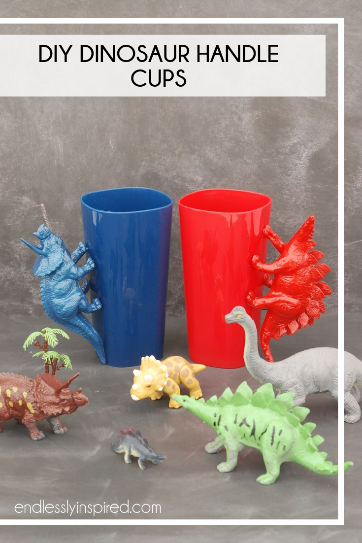 Blue and red dinosaur handle cups on a table with plastic dinosaurs
