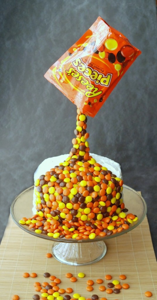 Learn how to make this amazing anti-gravity cake that looks like a bag of Reese's Pieces is being poured over the cake!