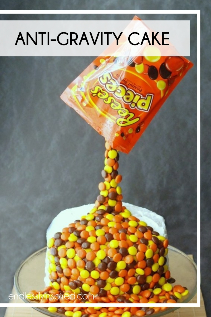 Cake covered with Reese's Pieces that look like they're being poured out of a bag.