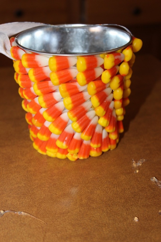 Make this super cute treat bucket out of a plain metal bucket and candy corn! #31DaysofHalloween