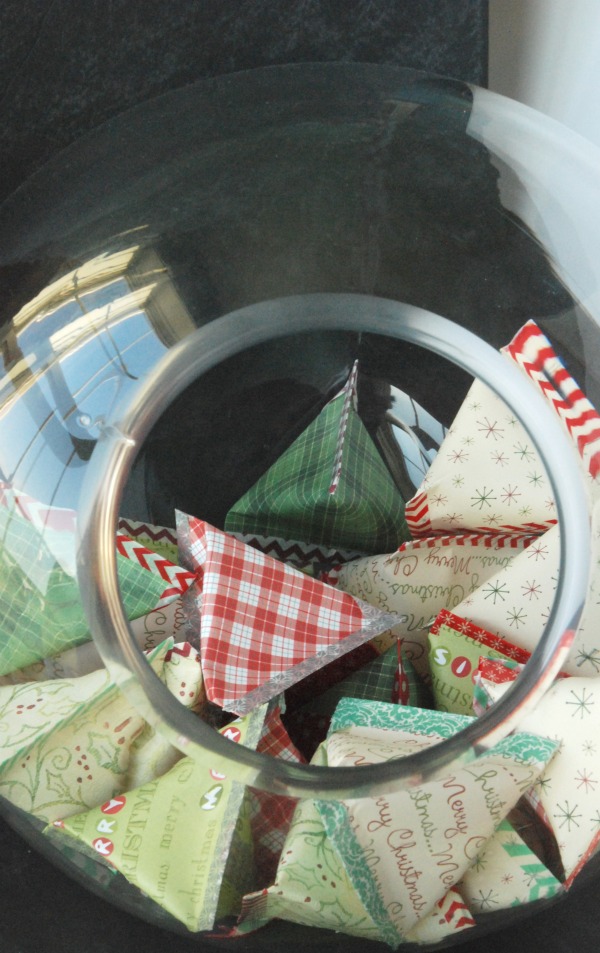 Scrapbook paper pouches in a clear glass bowl