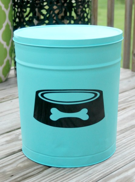 Use an old popcorn tin from the thrift store, some spray paint and a vinyl decal to make a super cute DIY Dog Food Canister!