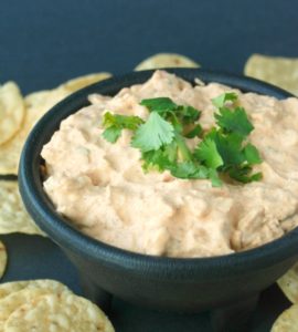 This chicken enchilada dip is creamy, easy-to-make and absolutely delicious. It will be the hit of your next party or tailgate!