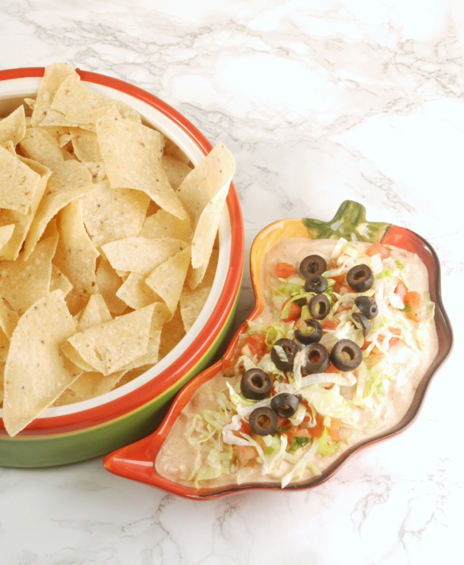 Make two-ingredient salsa chicken in your slow cooker, and then use it in a zesty taco dip that can be served hot or cold. Perfect for tailgating!