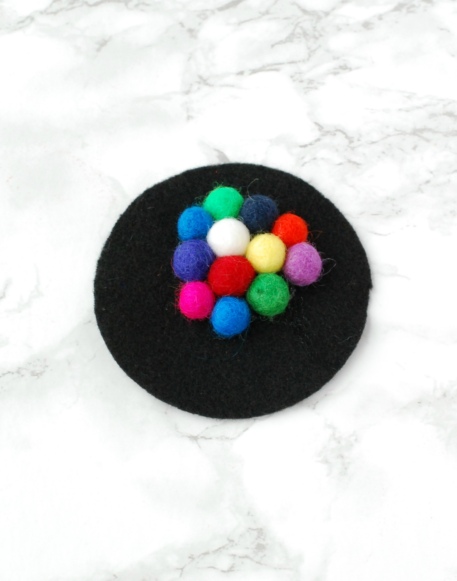 Felt ball coasters are easy and inexpensive to make, but add such a fun pop of color to your home.
