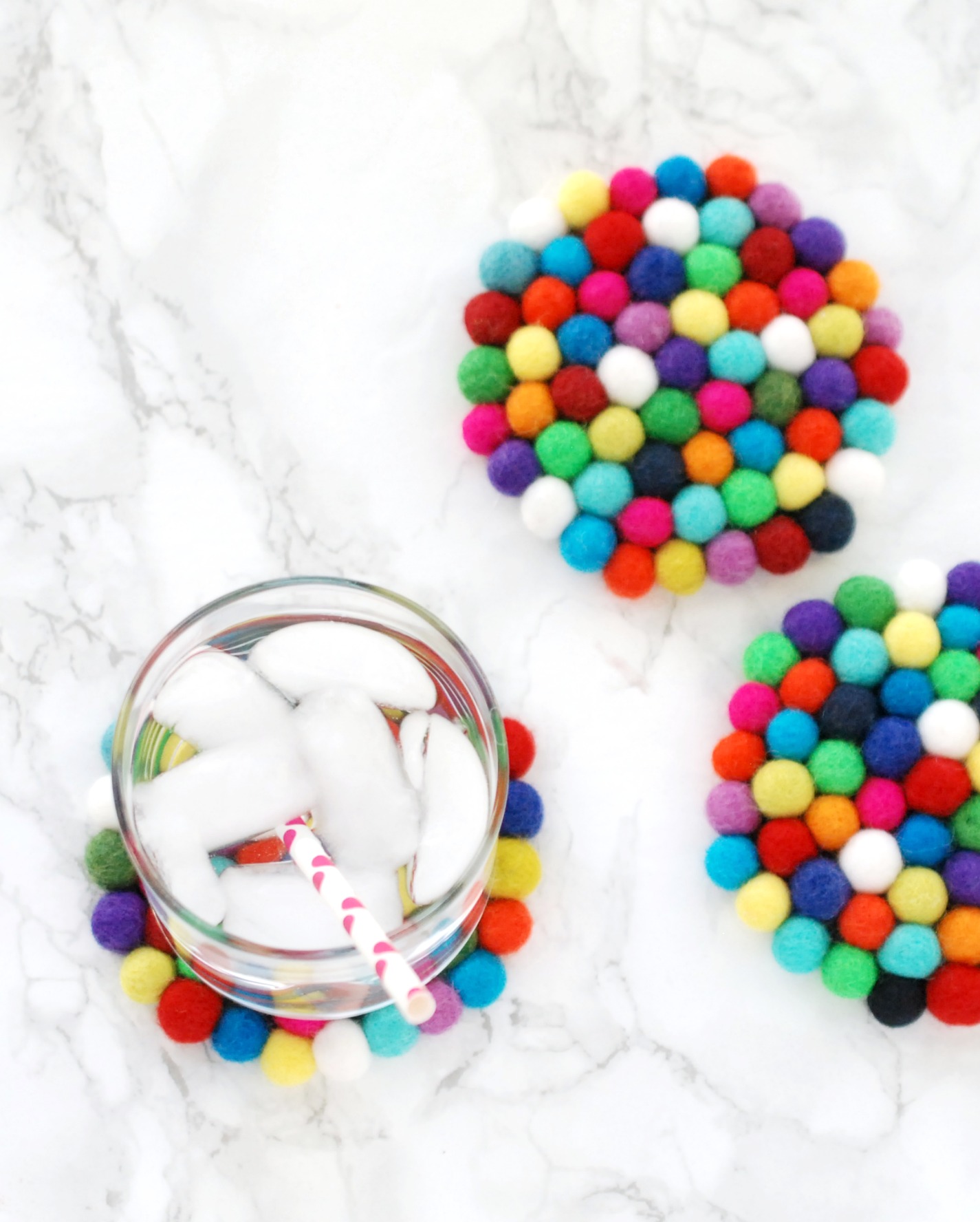 Felt ball coasters are easy and inexpensive to make, but add such a fun pop of color to your home.