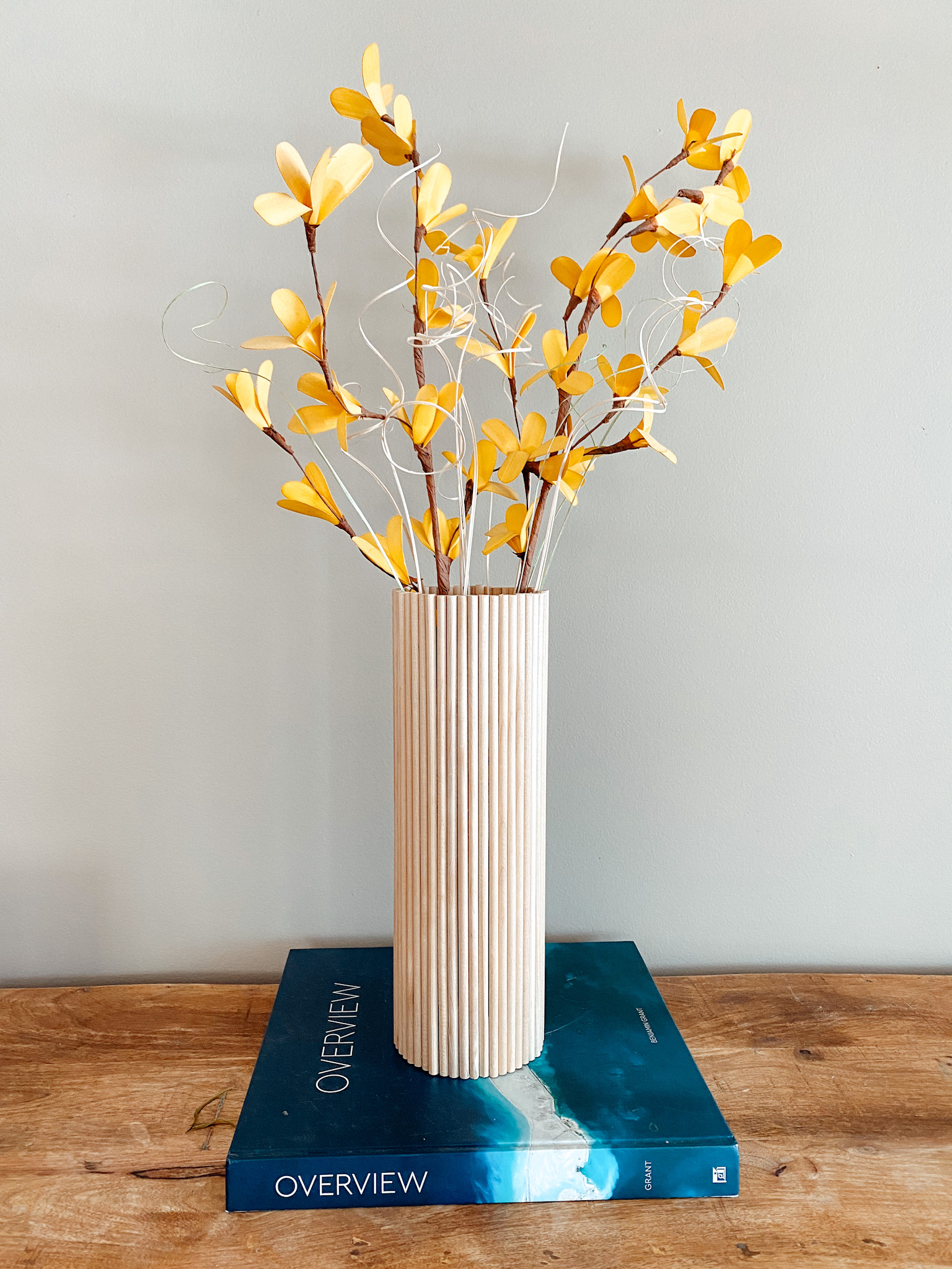 wood vase on display with yellow flowers