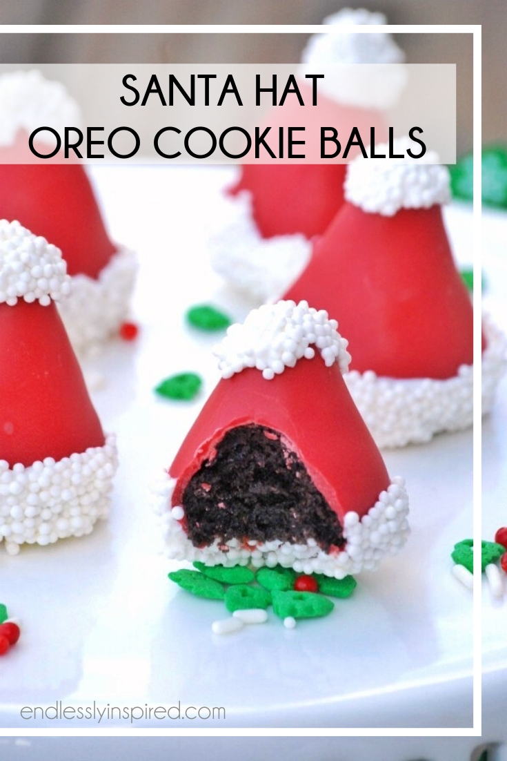 Santa Hat-shaped Oreo cookie balls on a white platter with green sprinkles.