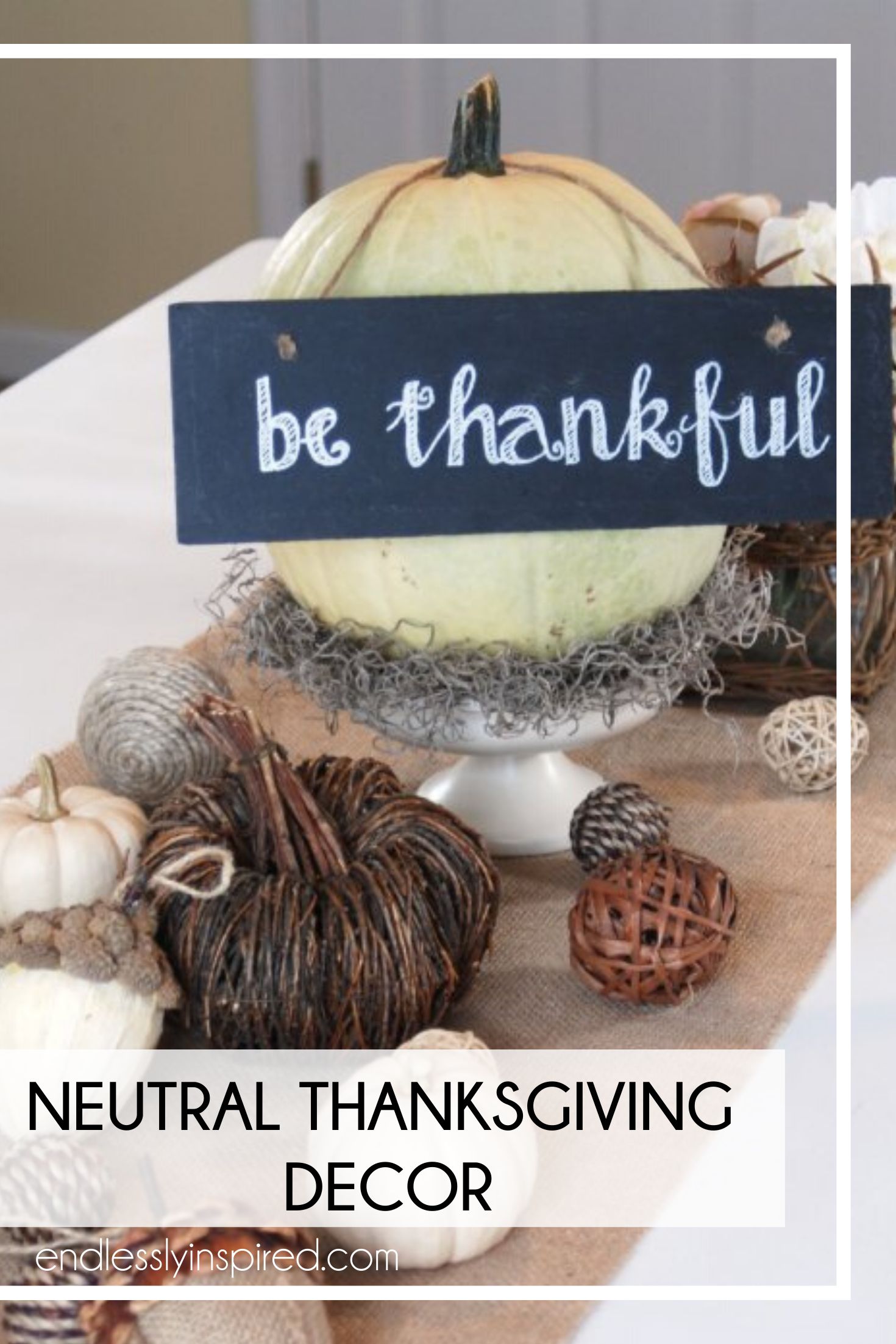 A table with a burlap runner, white pumpkins and other neutral fall decor