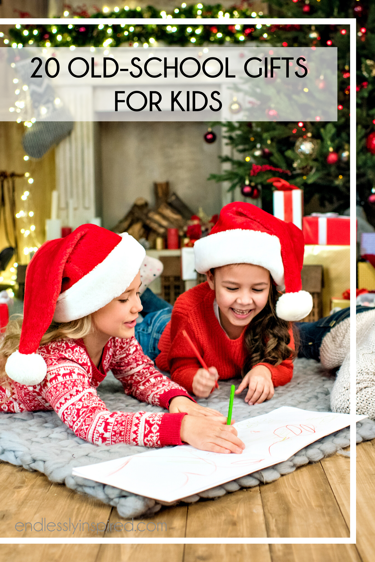 Two girls in Santa hats drawing in front of a Christmas tree